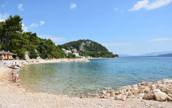 Oblázková pláž s pozvolným vstupem do moře.