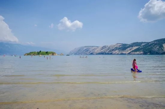 Písečná pláž s pozvolným vstupem do moře.