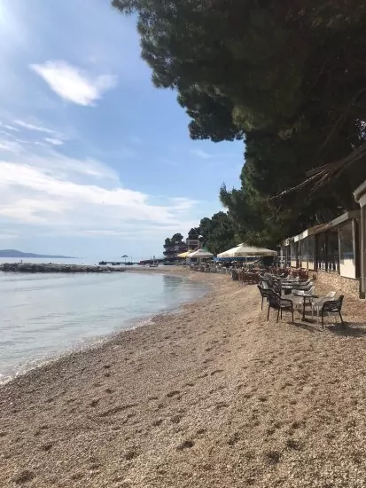 Oblázková pláž s pozvolným vstupem do moře.