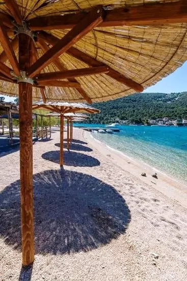 Oblázková pláž s pozvolným vstupem do moře.