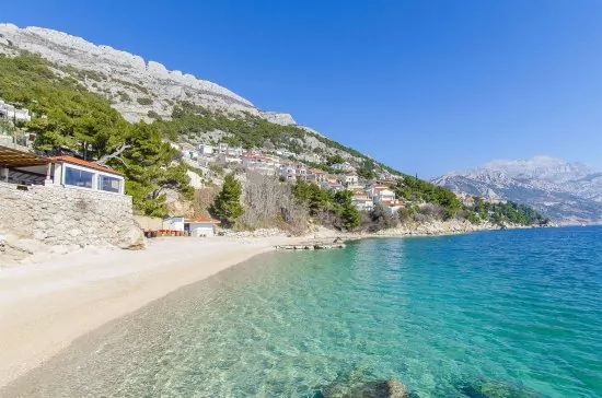 Oblázková pláž s pozvolným vstupem do moře.