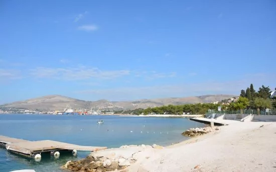 Oblázková pláž s pozvolným vstupem do moře.