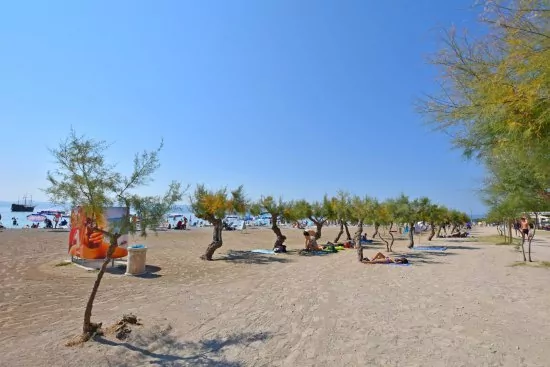 Písečná pláž s pozvolným vstupem do moře.