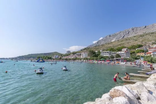 Písečná pláž s pozvolným vstupem do moře v městě Duće.