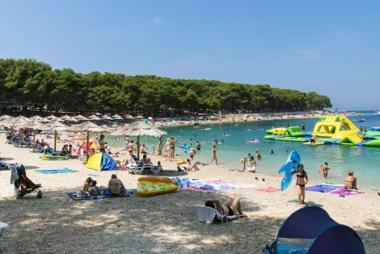 Oblázková pláž s pozvolným vstupem do moře.