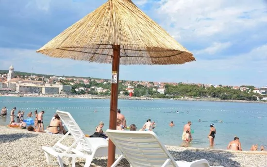 Oblázková pláž s pozvolným vstupem do moře.