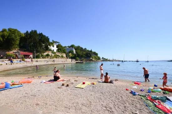 Oblázková pláž s pozvolným vstupem do moře.