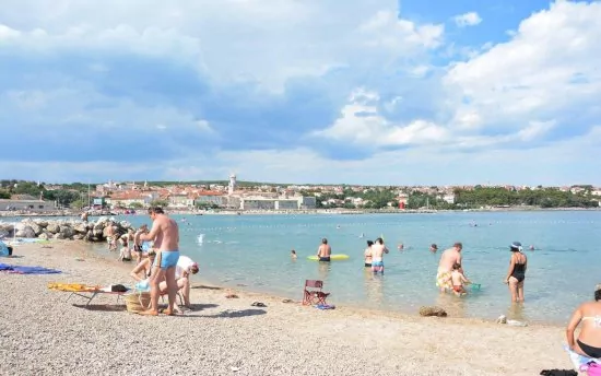 Oblázková pláž s pozvolným vstupem do moře.