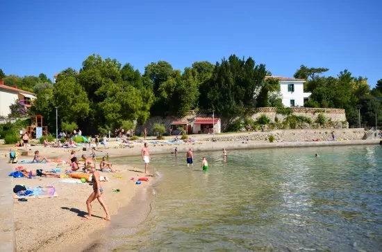 Oblázková pláž s pozvolným vstupem do moře.