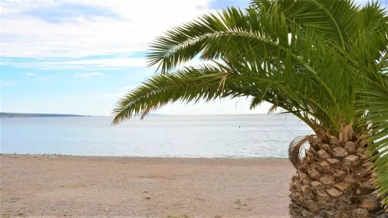 Oblázková pláž s pozvolným vstupem do moře.