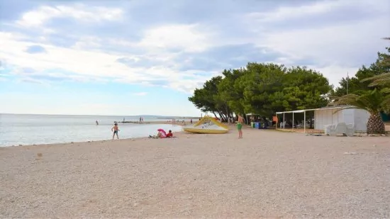 Oblázková pláž s pozvolným vstupem do moře.