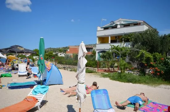 Dům po pravé straně a pláž přímo před ním.