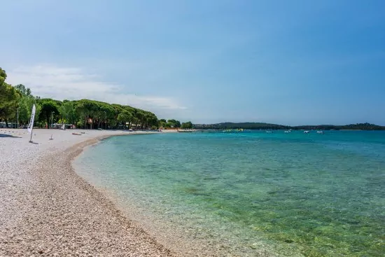 Fažana - oblázková pláž s pozvolným vstupem do moře.