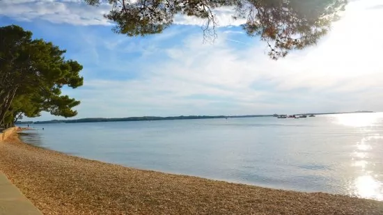 Fažana - oblázková pláž s pozvolným vstupem do moře.