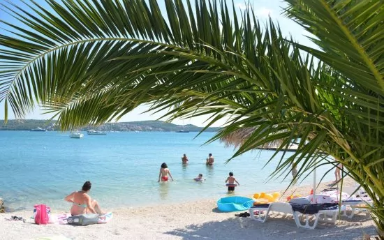 Oblázková pláž s pozvolným vstupem do moře.