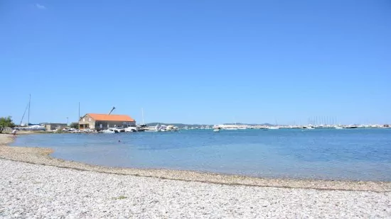 Sukošan - oblázková pláž podél pobřeží.