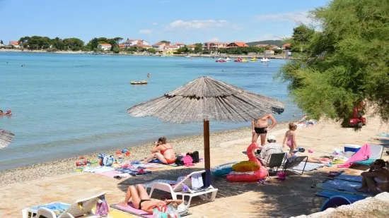 Sukošan - oblázková pláž podél pobřeží.