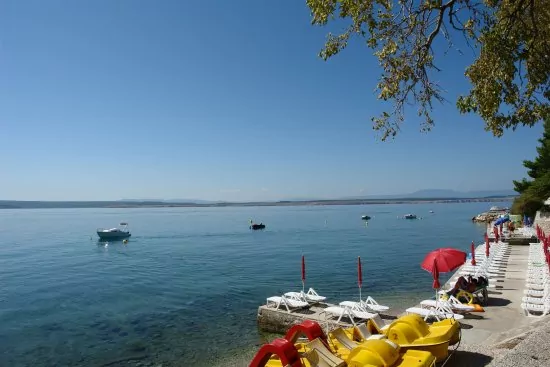 Oblázková pláž s betonovými moly.