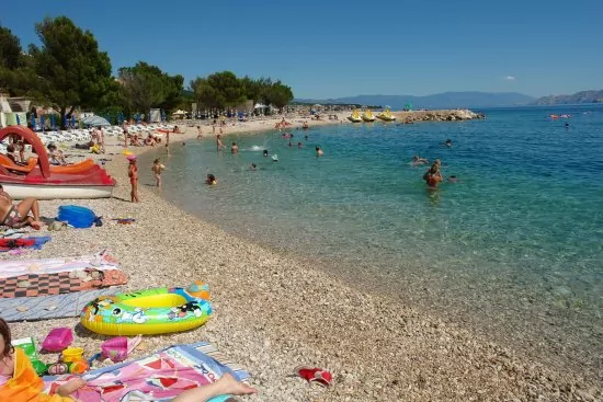 Oblázková pláž s pozvolným vstupem do moře.