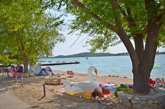 Vodice oblázková pláž s pozvolným vstupem do moře.