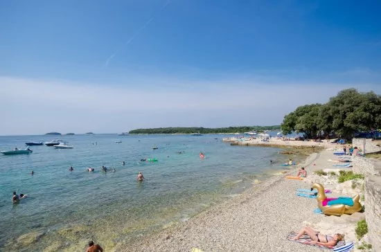 Vrsar oblázková pláž s pozvolným vstupem do moře.