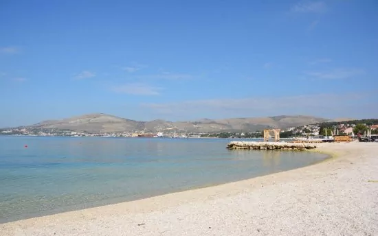 Oblázková pláž s pozvolným vstupem do moře.