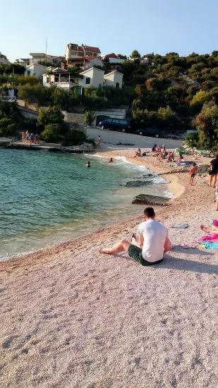 Oblázková pláž s pozvolným vstupem do moře.