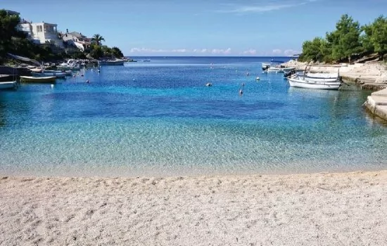 Oblázková pláž s pozvolným vstupem do moře.