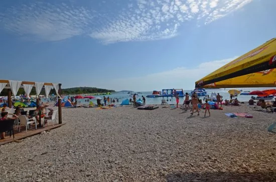 Oblázková pláž s pozvolným vstupem do moře.