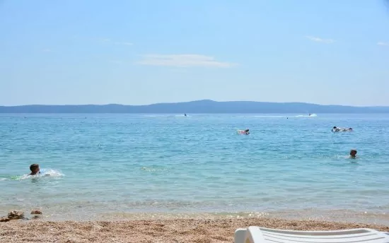 Oblázková pláž s pozvolným vstupem do moře.