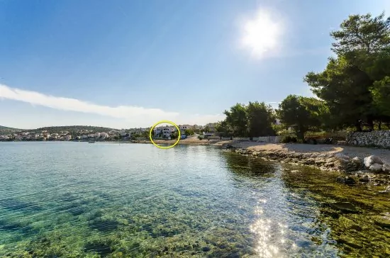 Dům přímo u břehu moře a oblázkové pláže.