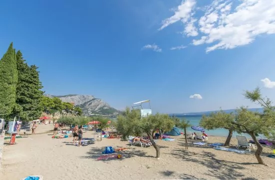 Písečná pláž s pozvolným vstupem do moře.